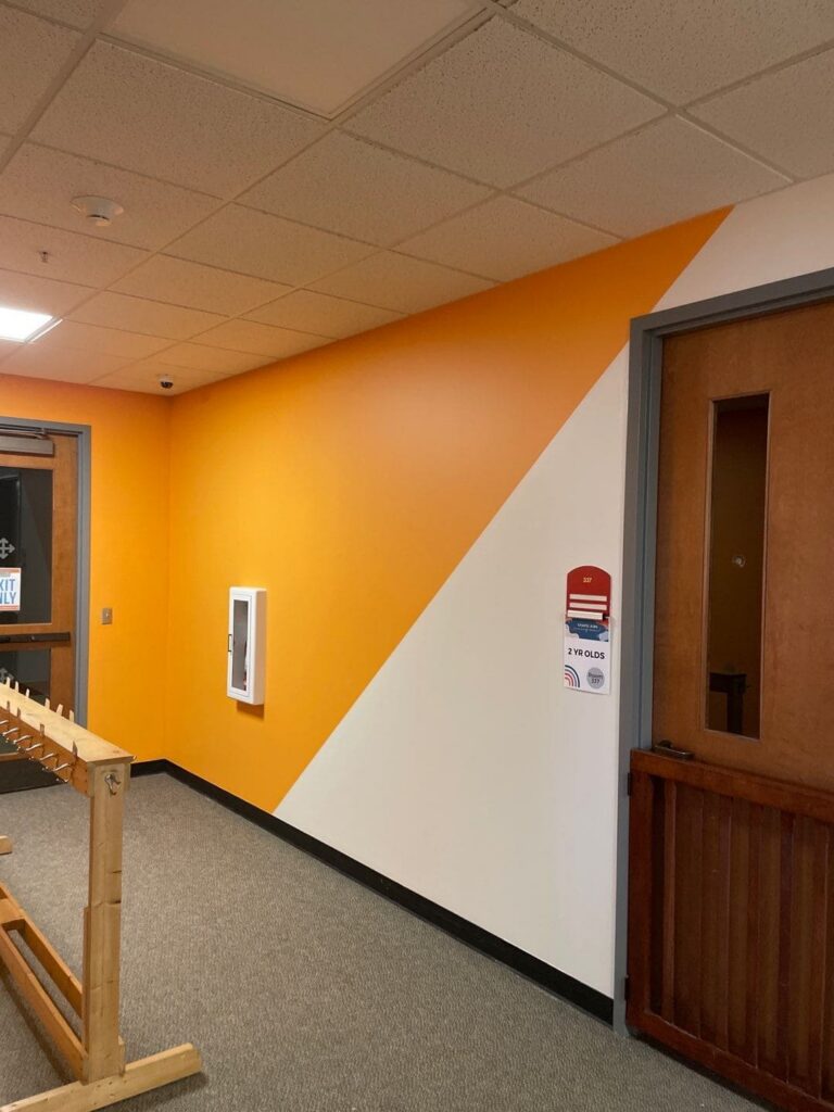 Geometric mural in hallway with orange and white triangle design