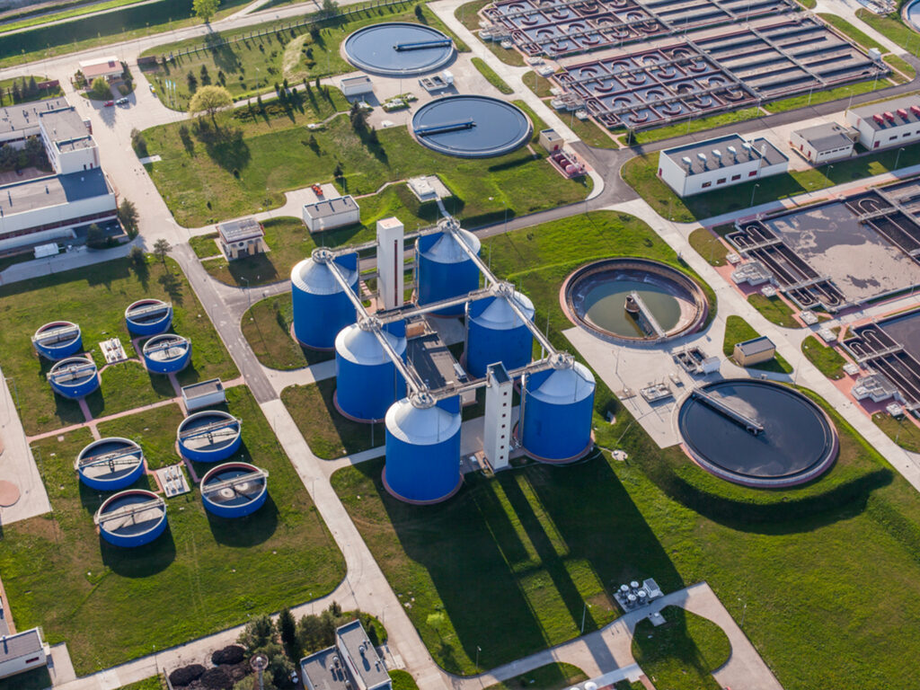 Aerial view of water treatment plant with large blue tanks