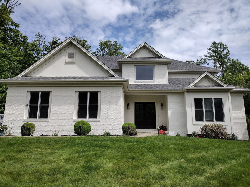 Modern suburban white brick house with lush green lawn
