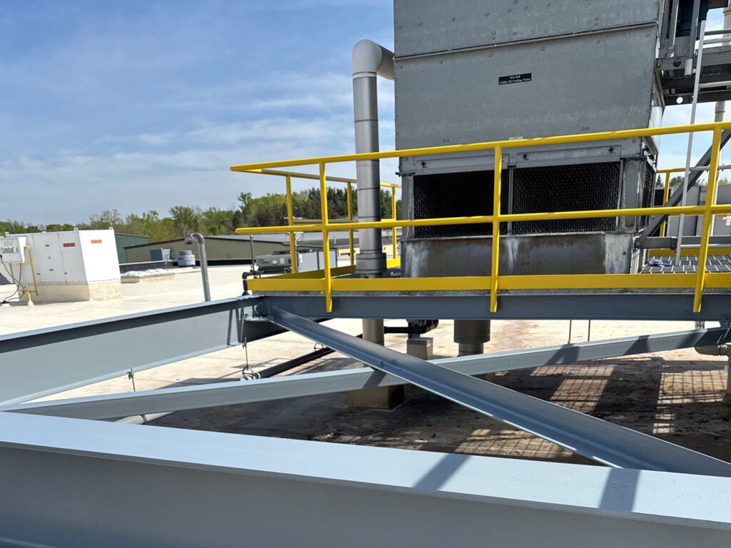 Rooftop industrial cooling tower with safety railings.