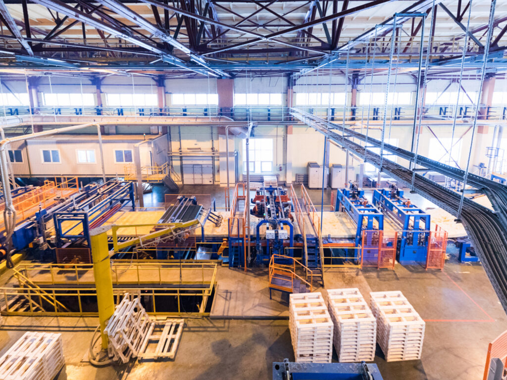 Interior view of a modern factory with machinery and storage units.