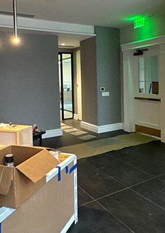Modern office entrance with unpacked boxes and hallway view.