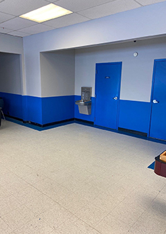 Empty waiting room with blue and gray walls and a water fountain.