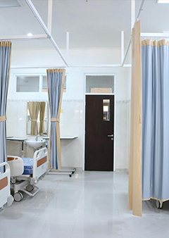 Modern hospital room with beds and privacy curtains.