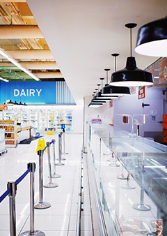 Modern grocery store interior featuring a well-lit dairy section