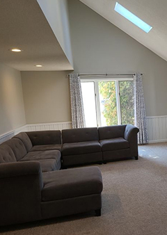 Spacious living room with gray sectional sofa and vaulted ceiling.