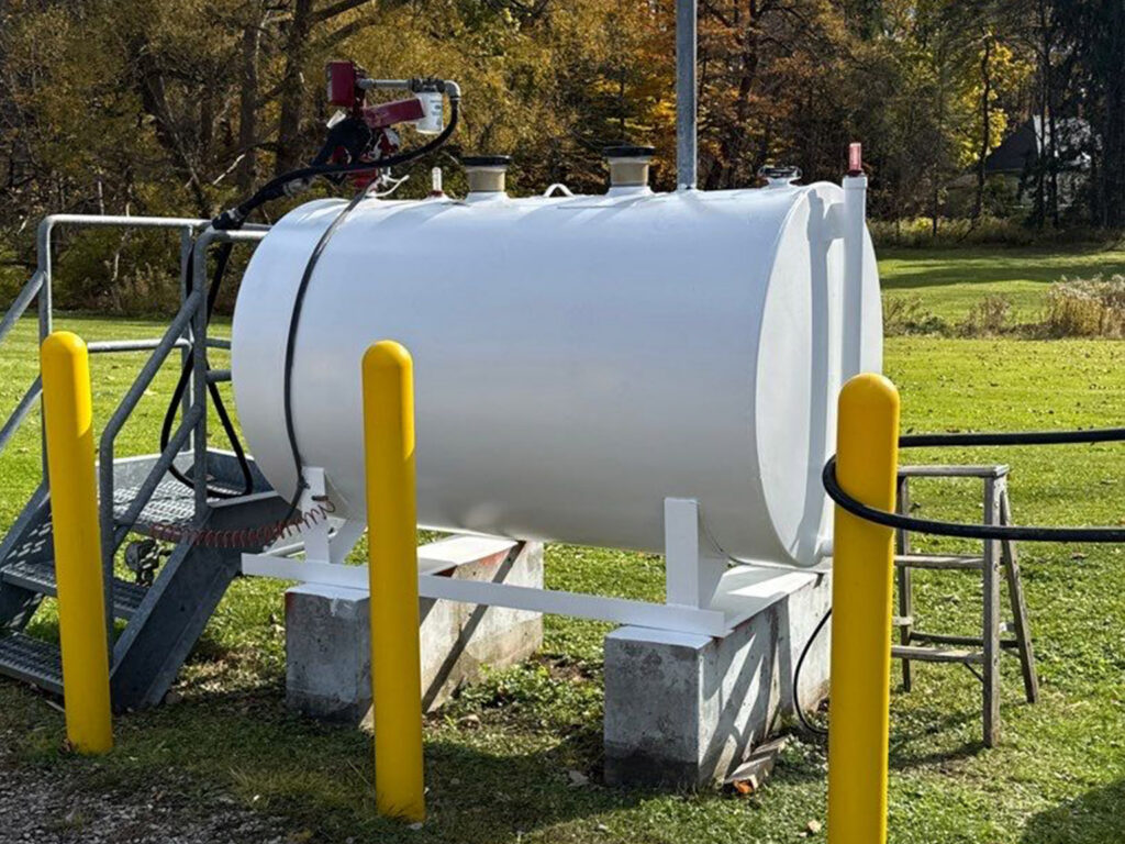 Outdoor white fuel storage tank with safety bollards