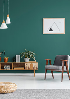 Modern living room with green wall, wooden furniture, and geometric decor.